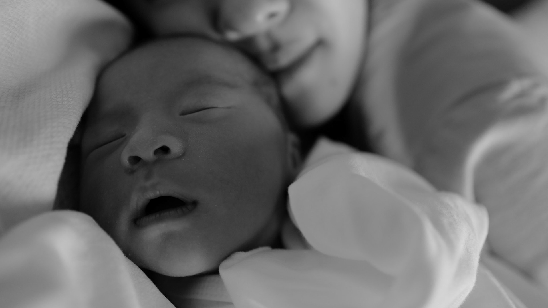 A newborn sleeping beneath a blanket